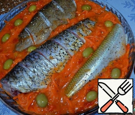 Put the vegetables and olives between the fish and pepper the fish .
Place in the oven and bake at 180-200 degrees for 35-45 minutes .