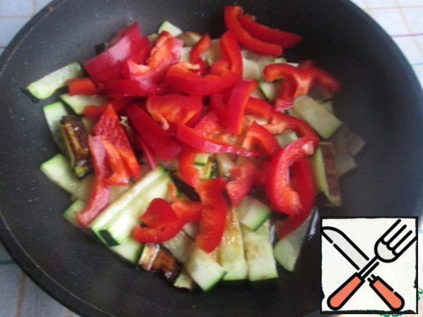 Cut the pepper without seeds into cubes, add to the zucchini, add a little salt and continue to fry, stirring, until cooked.