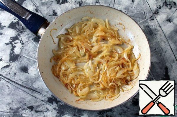 Cut the onion into strips.
In the same pan, fry the onion until golden brown.