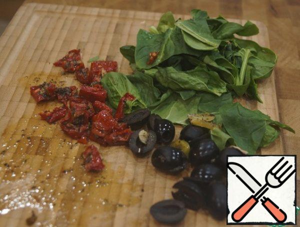 Olives cut into rings , dried tomatoes in small pieces. Wash and dry the spinach. By the way, for lack of sun-dried tomatoes, you can take a small amount of cranberries and cranberries.