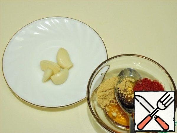 Prepare the baking mixture.
Grate or squeeze garlic, mix with honey, mustard powder and a mixture of red peppers,