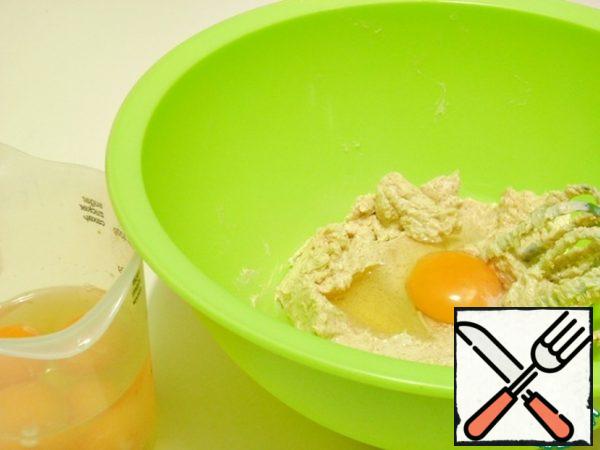 Pour one egg at a time into the butter-sugar mixture, beating at a low speed of the mixer.