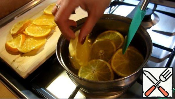 Cook the syrup from sugar and water.
Then add the orange slices and boil for 15 minutes.