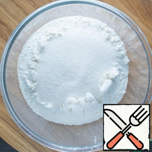 In a large bowl, sift the flour, add a pinch of salt and sugar.