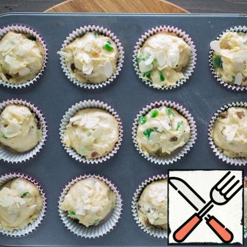 Put paper capsules in the cupcake mold, and put a tablespoon of dough into each capsule, filling it with 3 to 3 pieces . Spread out the almond petals on top. In total, it turns out about 20-24 muffins. Leave to approach for another 20-30 minutes.