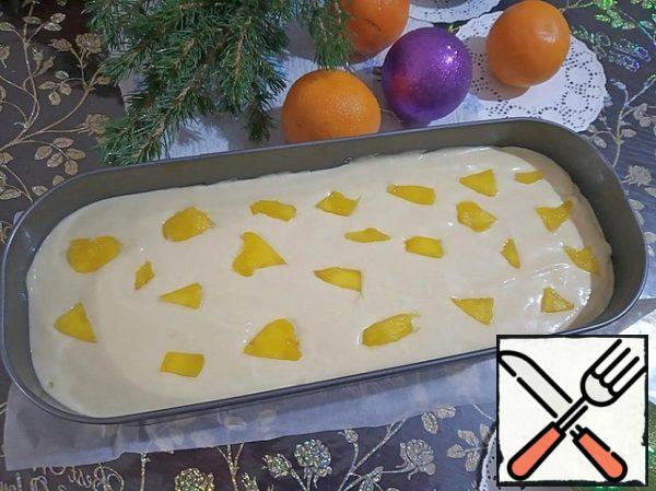 Carefully fill the tangerines with dough. Spread the rest of the mango slices on top of the dough.