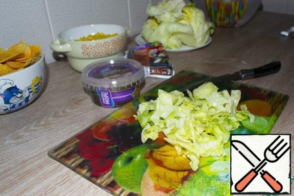 Then cut the lettuce leaves, also in medium slices, and add to the crab sticks.