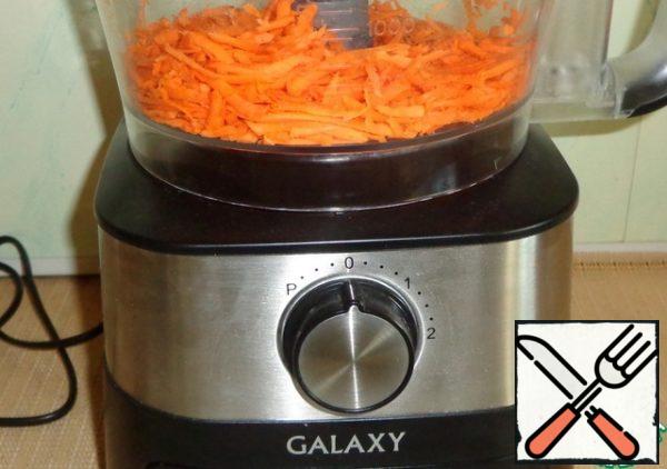 Using a food processor, grate the carrots with large straws.