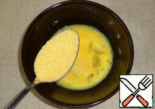 Break the raw egg into a bowl and shake it with a fork. Pour the couscous and mix.