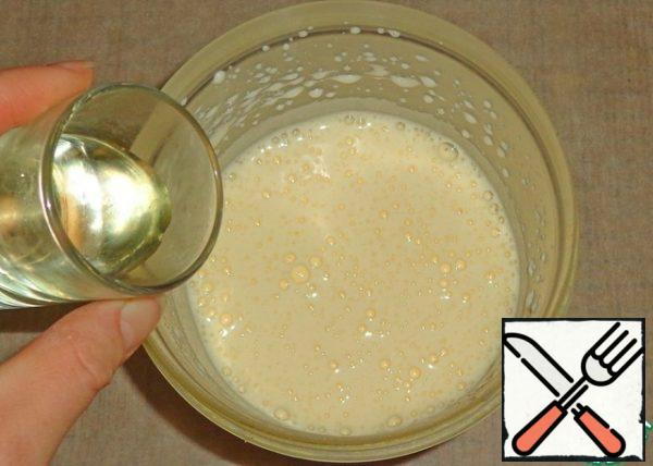 Now the dough can be mixed with a spatula. Pour the dough into a deep bowl, pour the vegetable oil.