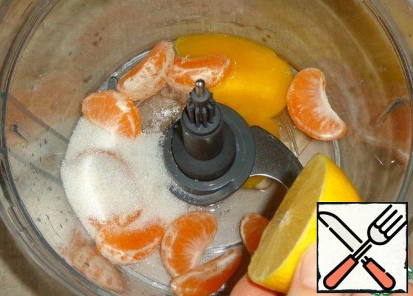 Insert a chopper knife into the bowl of the food processor . Break the raw egg, pour in the sugar, add the peeled tangerine slices and lemon juice.