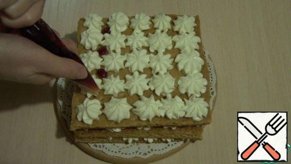 Next, put the second cake, repeat with the cream. And between the cream "roses", I added ready-made cherry jam ( you can use any other). We also make the third cake. And the fourth cake just spread cream, no jam. Decorate as desired, I have prepared stars and meringue.