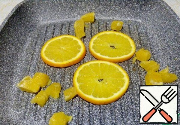 Brush the pan with oil, spread the rings and orange slices on it, warm it up, turning it over.