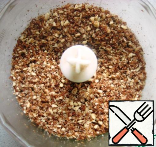 To design the sides of the cake, prepare the crumbs. Cut off the top of the biscuit pieces and walnuts in a blender to crumble.