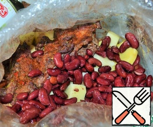 2 hours before serving, tie the bag and pierce it in two places.
Place in the oven and bake for 1 hour at 150 degrees.
Then untie the package.
Peel the potatoes, cut them , put them in a bag and add salt.
Add the beans with brine and tie the bag.