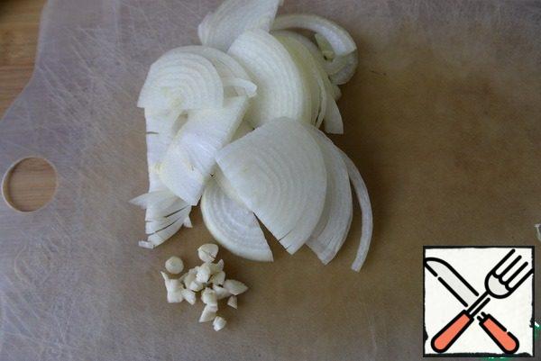 Peel the onion, cut it into half rings or strips, and finely chop the garlic. Put the onion and garlic in a preheated frying pan with vegetable oil, fry until the onion becomes transparent, over medium heat.