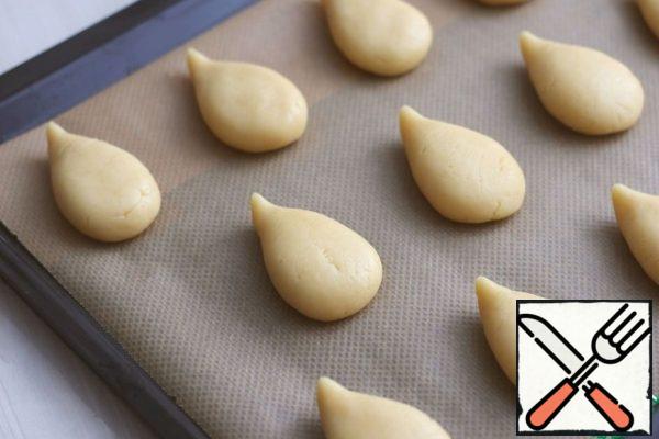 Then divide the dough into pieces, about 50 gr. Shape the cookies into droplets.
Place the cookies on a baking sheet covered with parchment and send them to the oven preheated to t190-200C.