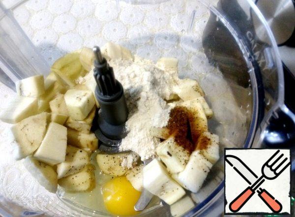 In the bowl of the combine with a knife attachment , put the eggplant cut into pieces, peeled from the skin, egg, flour, salt, pepper. All punch until smooth.
