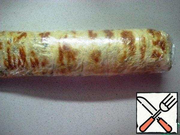 Carefully roll up the roll, separating the parchment. Then wrap it in plastic wrap and send it to the refrigerator for at least 2 hours. Then cut into pieces and serve to the table!