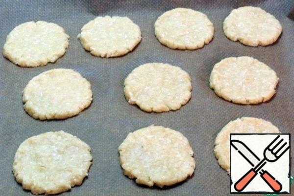 Put baking paper on a baking tray. From each ball of dough on paper to form a flat cookie larger than the circles of tangerine.