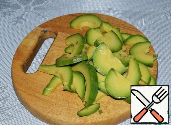 Peel the avocado and cut it into thin slices.