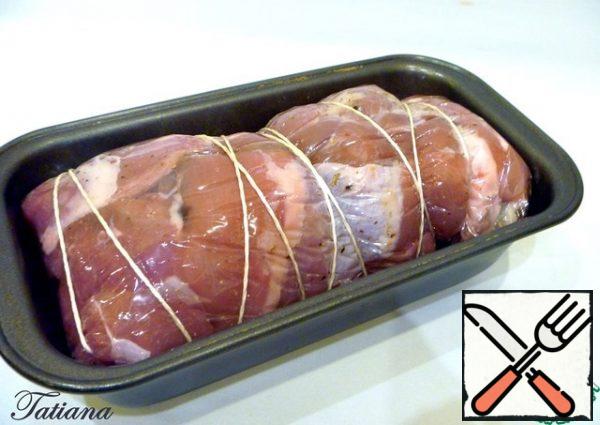 Roll the meatloaf with a film, pulling the sides tightly from the beginning and from the sides. Wrap the roll in cling film along the entire length of the film, additionally tie with a cooking cord. Transfer the prepared roll to a baking dish. Bake the roll in the oven at t 200 C, 30 minutes . Then reduce the heat to 170 degrees and cook for another 30 minutes. Hold the finished roll in the oven for another 20 minutes.