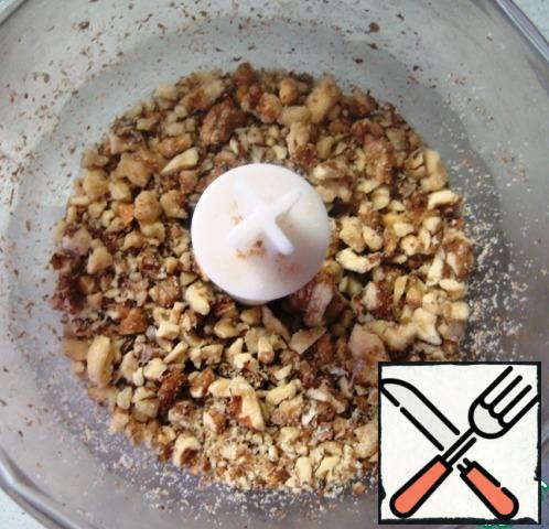 Chop walnuts with a blender (100 g-for the dough, 50 g-for decorating the cake (optional)).
