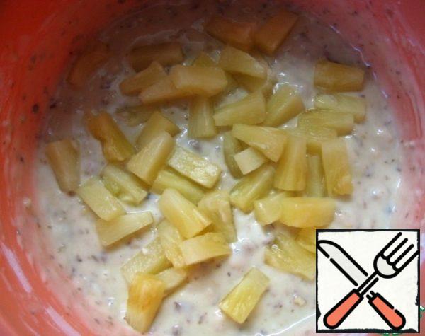 Add pineapple slices (remove them from the jar and let the syrup drain). Gently knead the dough.