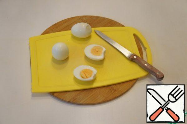 Cut the cooled eggs in half and remove the yolks with a spoon.
