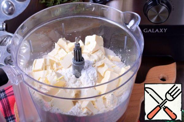 Everything is simple with the dough, especially when there is such an assistant as a food processor. Install a knife for chopping food.
All the ingredients for the dough, except eggs, are loaded into a bowl (cold butter should be cut into cubes in advance).
Turn on the combine for a few seconds (speed "1") so that the oil and dry ingredients mix.