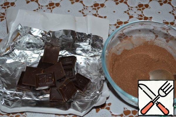 Preparing a velvet truffle sponge cake: break the dark chocolate. Mix sugar with cocoa.