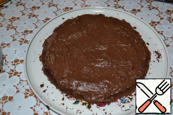 Divide the cooled chocolate cream into two parts. Smear the bottom of the cake cake.
