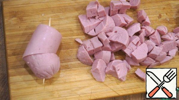 Sausage, sausage, or whatever you have there - finely cut. From sausages, you can immediately make blanks for the design of muffins.