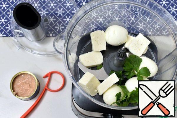 In the bowl of a food processor, put the peeled hard-boiled eggs, add parsley leaves and sliced cheese. If the cheese is too salty or hard, pre- soak it. I came across an extremely tender fresh cheese.