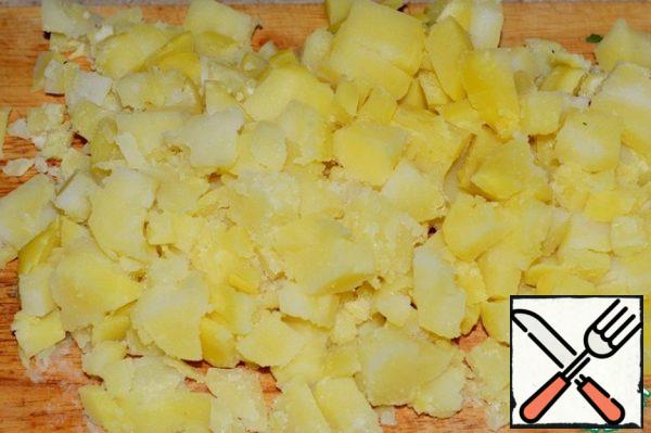 Boil the potatoes, cool and cut into small cubes.