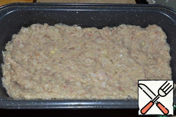 The form is greased with vegetable oil. Spread some of the minced meat.