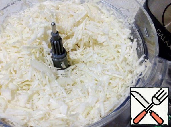 Use the slicing attachment to chop the cabbage.