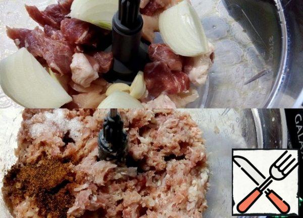 In parallel, we prepare the meat filling. Cut the pork and chicken breast into pieces, add the onion and garlic, and use a sharp chopping knife to prepare the mince.