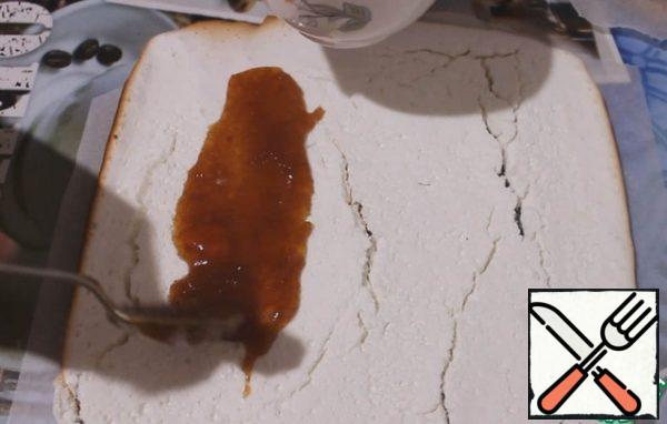 We take it out of the oven as soon as the edges are browned, so everything is ready. Inside, it remains soft and sticky. When it cools down, the top will become crispy.
Turn over and smear with caramel. We try to carefully twist the roll. It will be very cracked and slightly cracked, as it should be.