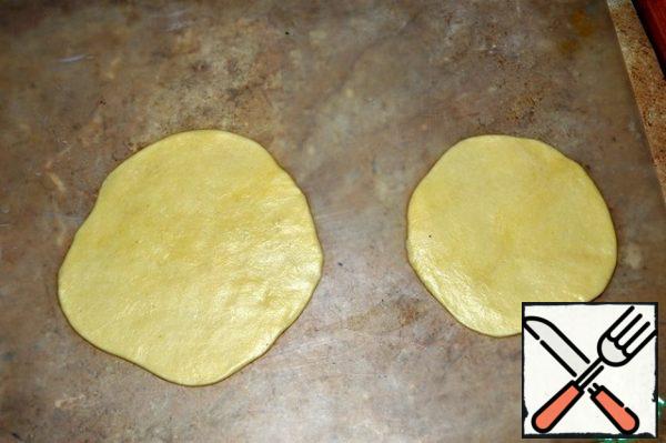 From the dough, we pinch off small pieces and roll out into pancakes. The dough is soft and elastic, so the process will not be difficult.