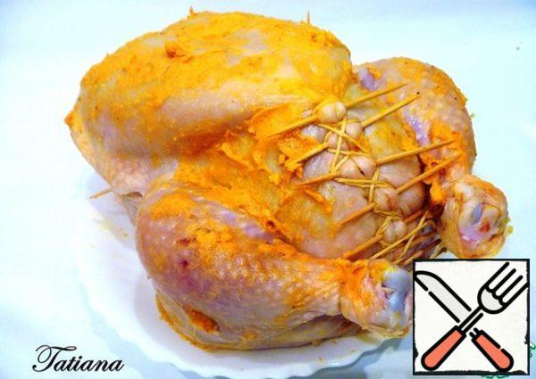 Prepared chicken (pre-wash and dry, both outside and inside), smear the inside with garlic and orange butter, a little salt, fill tightly with minced vegetables. The hole is fastened with wooden toothpicks, additionally tighten the cooking cord, grabbing the shins. Just attach the wings to the chicken carcass with toothpicks. Use a cooking cord to tie the base on top (you can cut off any excess skin). In the fleshier parts of the chicken (breast, thighs and shins), make small slits, using a thin knife, fill the recesses with garlic and orange butter. Brush the chicken with the remaining butter on all sides and add a little salt.