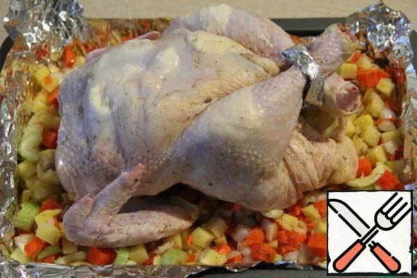 Carefully separate the skin on the breast and shins. Pour the remaining cheese and oil mixture under the skin and "massage" to distribute the mixture. Tie the legs.
Put the breast up on the vegetable mixture.