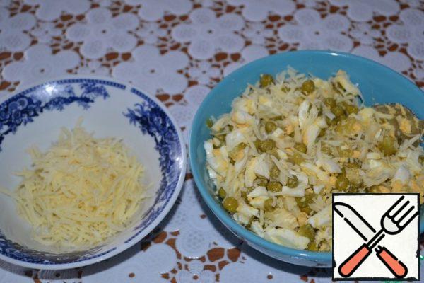 Grate 80 g of cheese on a fine grater. Mix 50 g with egg-cucumber-pea mass. We will need the remaining 30 g of cheese to sprinkle the roll.
