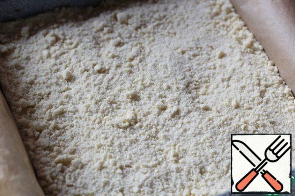 Put 1/4 of the crumbs in the refrigerator.
Put the remaining 3/4 crumbs in a mold (20x20 cm), covered with baking paper.
Don't interfere!