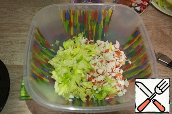 Then cut the lettuce leaves into medium slices and add to the crab sticks.