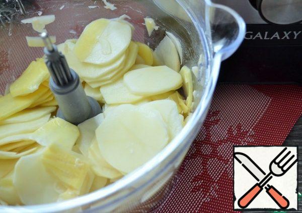 Peel the potatoes and cut them into thin slices in a combine.
