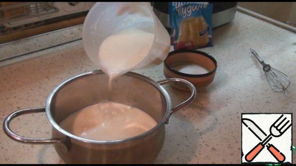 For the cream, pour about 600 ml of milk into a saucepan, add sugar and put on fire, bring almost to a boil. Meanwhile, pour 2 bags of pudding into the remaining 200 ml of milk, stir well.