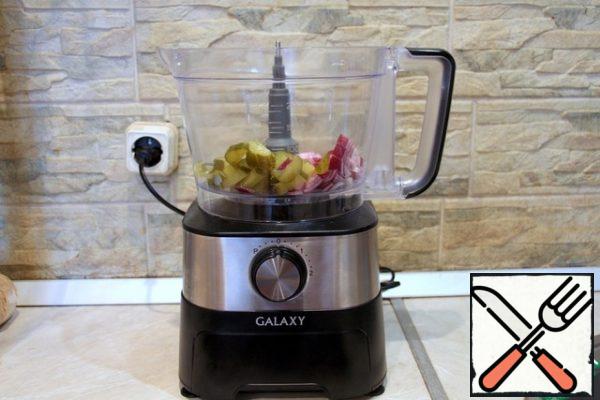 Chop the onion and pickled cucumbers in a food processor using cutting knives. Squeeze out excess juice with your hands.