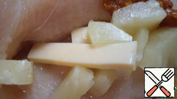 On each half of the breast, make an incision, so that a pocket would be formed. Fill with cheese and pineapple slices.