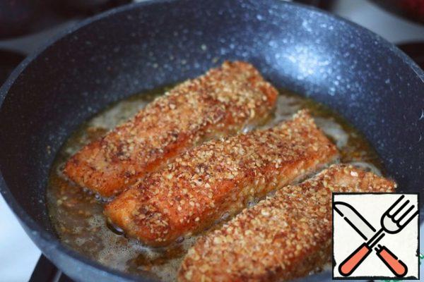 Fry each side of the salmon fillet for a few minutes.